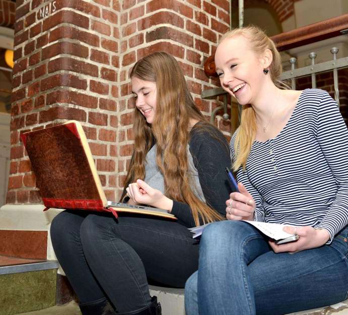 To skolepiger på trappen indenfor